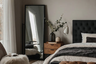 A wide full-length mirror enhancing a bedroom space with ample reflection