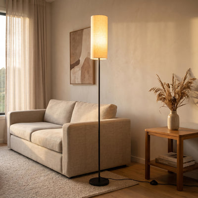 Chandelle Linen Column Floor Lamp glowing warm beside a sofa in a New Zealand living room at night