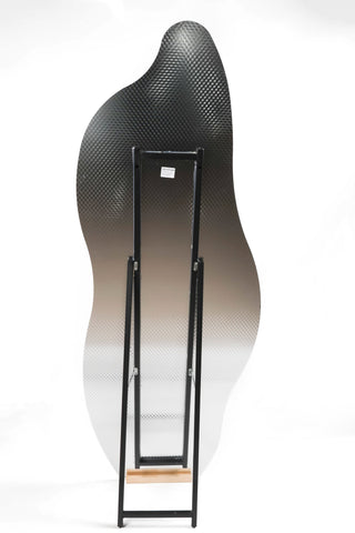 Rear view of the Cascade Irregular Frameless Full-Length Freestanding Mirror showing the metal stand structure and wooden base for support.