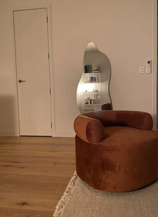 Customer photo of the Cascade Irregular Full-Length Mirror mounted in a cosy, modern living room with warm tones and wooden flooring, showcasing fast delivery and seamless style integration.