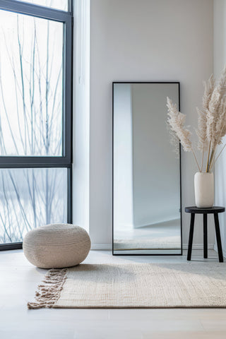 Facet straight-edged full-length mirror with sleek, minimalist design, placed in a modern room setting near a window with natural light.
