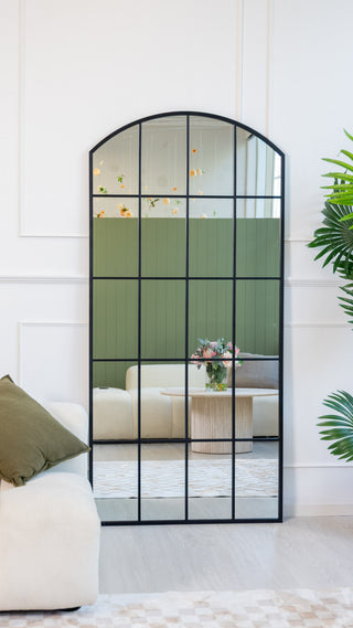 Mobile view of the Le Beau 190x90cm arched window full-length mirror by C&F Creation, styled against a white wall with a soft sofa and indoor plant beside it.