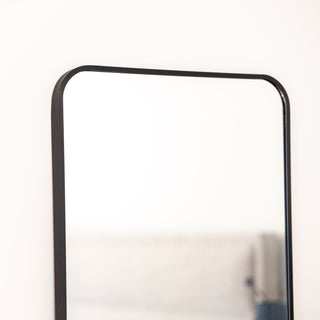 A close-up view of the Lithe X Full-Length Mirror, highlighting its sleek, rounded black frame and minimalist design. The elegant craftsmanship and smooth edges enhance its modern aesthetic, perfect for any contemporary space. | C&F Creation