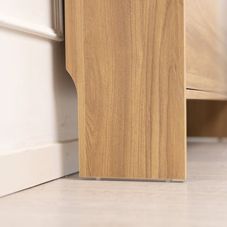 Close-up of the Risa Slim Shoe Cabinet leg in a natural oak finish, showing the sturdy base and clean-lined edge detail against a light wooden floor and wall trim