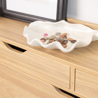 Close-up of the Risa Slim Shoe Cabinet in oak finish, showing the top surface styled with a white ceramic tray holding coins, next to a framed artwork. The cabinet’s smooth grain and handleless top drawers add to its minimalist, modern design.