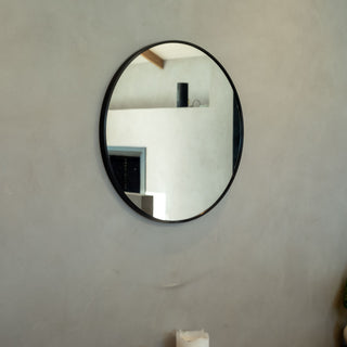 Valor Round Wall Mirror with a sleek black aluminium alloy frame, elegantly mounted on a neutral wall in a modern interior | C&F Creation