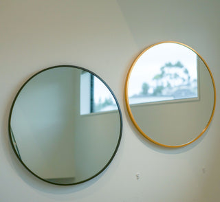 Valor Round Wall Mirror featuring sleek black and gold aluminium alloy frames, elegantly mounted on a neutral wall with natural light | C&F Creation
