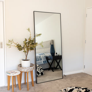 Zenith Full-Length Mirror 180x80 with a contemporary black border, reflecting a chic bedroom with a bedside table and decorative elements. Elevate your home aesthetic effortlessly. | C&F Creation