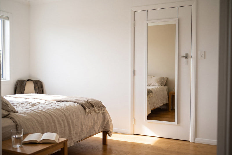 Over the door mirror NZ, Elodie white framed full length mirror hanging over a white interior door in a bright New Zealand rental bedroom, full head to toe reflection with no drilling