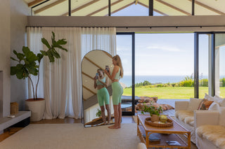 Beautiful woman practicing yoga in front of the Grandeur Arched Full-Length Mirror