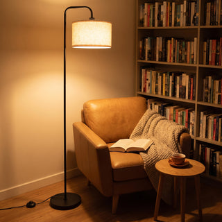 Marceau linen drum floor lamp arching over an armchair in a quiet reading corner