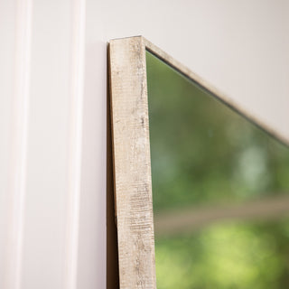 Detail shot of the Branewood 180x80cm full-length mirror highlighting its natural textured PS frame with a rustic wood finish. The 4mm clear glass and minimalist edge design reflect bright greenery, showcasing the mirror’s refined craftsmanship and versatility for both wall-mounted and floor use in modern interiors.