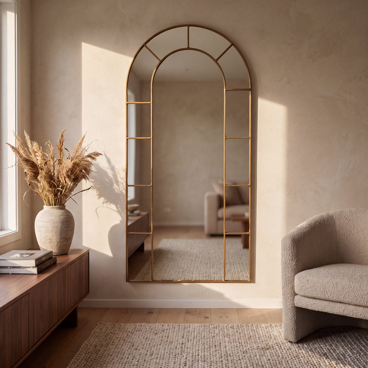 Bastia Aurelia antique gold arched window full length mirror 200 x 100cm on a limewashed living room wall in warm light