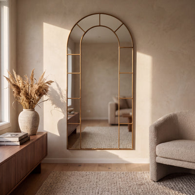 Bastia Aurelia antique gold arched window full length mirror 200 x 100cm on a limewashed living room wall in warm light