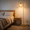 Camille Amber Petal Glass Floor Lamp casting a soft warm glow beside the bed in a cosy bedroom