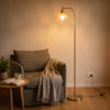 Camille Amber Petal Glass Floor Lamp lighting a relaxed reading corner beside an armchair
