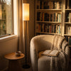 Chandelle Linen Column Floor Lamp lighting a comfortable armchair in a quiet reading corner