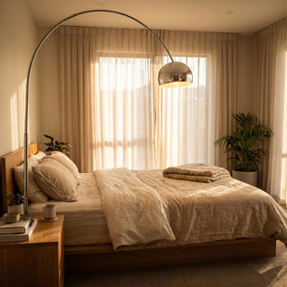 Cosmo Chrome Marble Base Floor Lamp arching over a bedside corner in a cosy New Zealand bedroom