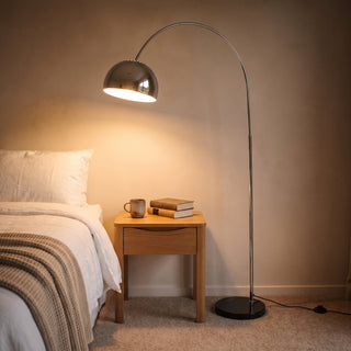 Cosmo Chrome Marble Base Floor Lamp arching over a bedside corner in a cosy New Zealand bedroom