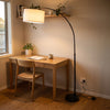 Flore Black Arc Floor Lamp lighting a quiet home office desk from above