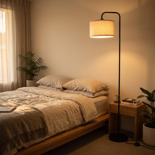 Marceau Linen Drum Floor Lamp casting soft light next to the bed in a cosy bedroom