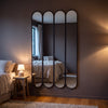Ravel quad oval black cast iron full length mirror 200 x 100cm in a bedroom at dusk