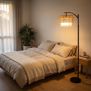 Rousseau Rattan Weave Floor Lamp casting a soft glow beside the bed in a cosy bedroom