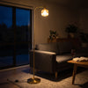Solara Fluted Lantern Floor Lamp switched on at night, its fluted amber glass shade glowing in a dark evening living space