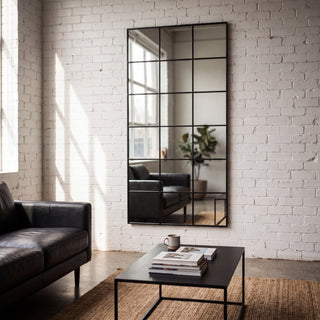 Tivoli X black rectangular window full length mirror 200 x 100cm on a white brick loft wall beside a leather sofa
