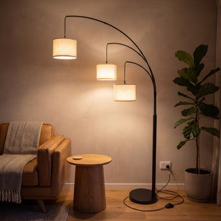 Trilogy 3-Light Floor Lamp lighting a lounge corner beside a leather armchair