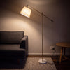 Vienna Brass Marble Base Floor Lamp glowing warm at night as the only light in a dark living room