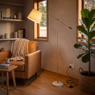 Vienna Brass Marble Base Floor Lamp angled over a leather reading chair