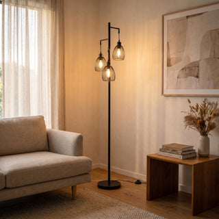 Voltaire 3-Light Cage Floor Lamp glowing warm beside a sofa in a New Zealand living room at night
