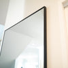 The Facet wall mirror reflecting a bright minimalist interior, perfect for home decor.