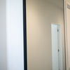 A close-up of the wall-mounted Facet full-length mirror, showcasing its premium frame and installation.