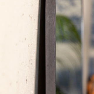 Close-up side view of the Grandeur X arched mirror showing its 30mm thick black aluminium alloy frame. The image highlights the brushed metal texture and solid craftsmanship, giving a clear sense of the mirror’s durability and premium finish.