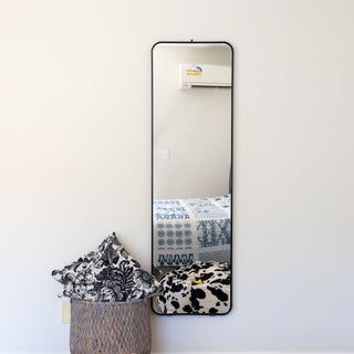 A sleek and modern Lithe X Full-Length Mirror (155x45cm) wall-mounted in a contemporary bedroom. This wall mirror features a slim black frame, adding a minimalist touch to any space. Its space-saving design makes it perfect for small bedrooms, dressing areas, or hallways. The high-quality glass ensures a clear and accurate reflection, making it an essential home décor piece. | C&F Creation