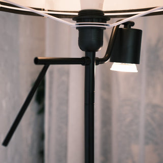 Close up of the Lumen Duo Floor Lamp showing the adjustable reading light and black metal stem, with warm illumination highlighting the clean lines and modern design.
