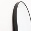 A close-up view of the Lumi Oval Wall Mirror’s sleek black metal frame, showcasing its smooth curvature and high-quality craftsmanship. This wall-mounted full-length mirror is perfect for modern interiors, adding a minimalist and stylish touch to bedrooms, dressing rooms, and living spaces. | C&F Creation
