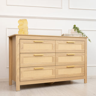 Side view of the Raya 6 Drawer dresser with rattan panel drawer fronts, brass handles, and oak wood finish, styled with decorative items on top, showing depth and structure of the piece.