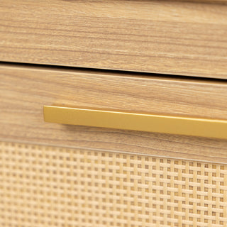 Close-up of the Raya 6 Drawer dresser showing the sleek brass handle, oak wood finish, and rattan panel detail, highlighting craftsmanship and texture.