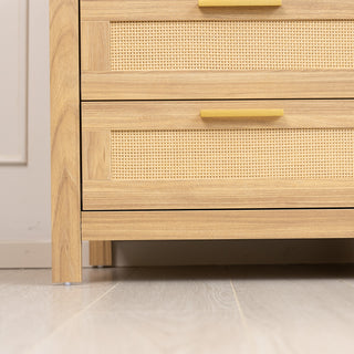 Close-up view of the Raya 6 Drawer dresser showing the oak-finished leg and lower rattan-fronted drawer, emphasising the natural wood grain and sturdy build on a light floor setting.