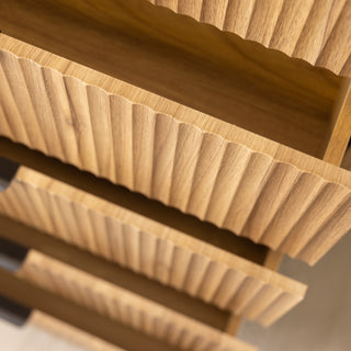 Angled close-up of the Reede Tallboy 5-Drawer showing the vertical fluted drawer front design, capturing the textured oak finish and smooth craftsmanship.