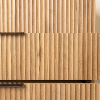 Detailed close-up of the Reede Tallboy 5-Drawer in oak finish, highlighting the vertical fluted front design, smooth texture, and modern craftsmanship.