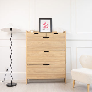 Full front view of the Risa Slim Shoe Cabinet in a bright modern living space, featuring three shoe compartments and two top drawers, finished in warm oak with a slim profile. Decor items include a framed artwork, floor lamp, and accent chair for styling.