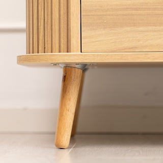 Close-up view of the Ruelle 6 Drawer dresser showing the solid angled wooden leg with secure metal bracket, highlighting the oak wood finish and sturdy base construction.