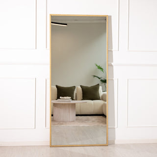 Tresson 180x80cm full-length mirror featuring a slim gold PS frame with a refined straight-edged design. The 4mm clear glass provides a crisp reflection of a modern living room with neutral tones and soft lighting, ideal for both wall-mounted and floor styling in elegant New Zealand interiors.