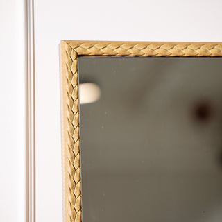 Close-up view of the Tresson gold full-length mirror corner, showing its intricate braided PS frame with a soft metallic finish. The 180x80cm mirror features 4mm clear glass and a refined design that brings warmth and elegance to contemporary New Zealand interiors.