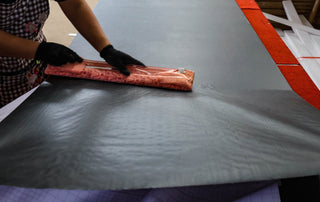 A worker carefully wraps the mirror’s shatter-resistant backing for protection, showcasing the detailed packaging process at the C&F Creations factory.