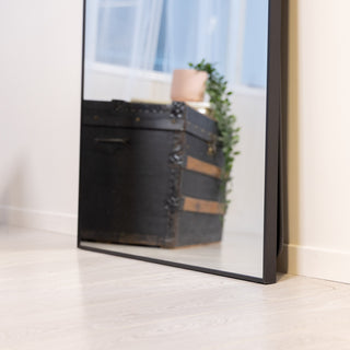 Floor-level view of the Zenith X full-length mirror highlighting the mirror’s sleek frame and stable standing support in a home setting.
